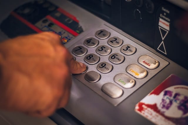 Close-up of a person using an ATM keypad 